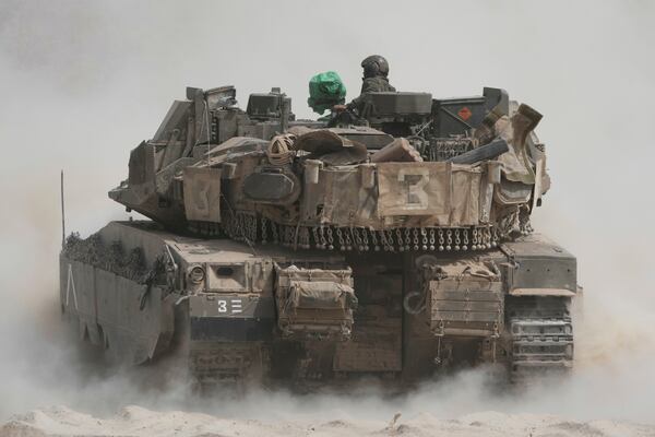 Israeli soldiers move tanks around staging area near the border with the Gaza Strip, in southern Israel, Sunday, May 18, 2025. (AP Photo/Ariel Schalit)