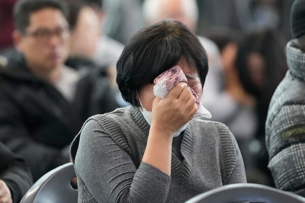 A relative of a passenger of a plane which burst into flames reacts at a temporary shelter at Muan International Airport in Muan, South Korea, Monday, Dec. 30, 2024. (AP Photo/Ahn Young-joon)