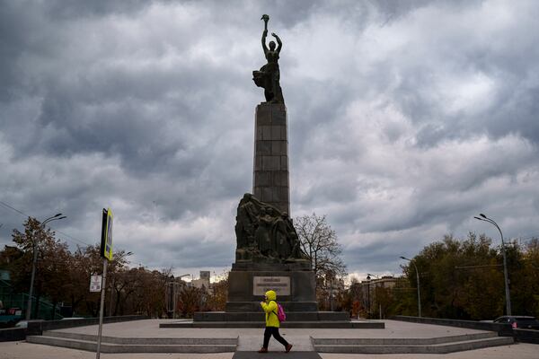 FILE - A person walks by the monument of the Leninist Komsomol Heroes, a political youth organization in the Soviet Union, in Chisinau, Moldova, Monday, Nov. 4, 2024. (AP Photo/Vadim Ghirda, File)