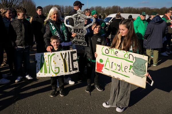 Young Plymouth fans hold banners outside the stadium before the English FA Cup fourth round soccer match between Plymouth Argyle and Liverpool at Home Park stadium in Plymouth, England, Sunday, Feb. 9, 2025. (AP Photo/Alastair Grant)