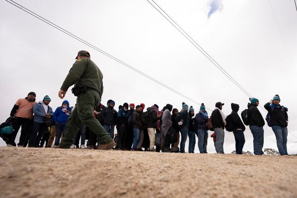 FILE - Men seeking asylum, including Peruvians, line up as they wait to be processed after crossing the border with Mexico nearby, on April 25, 2024, in Boulevard, Calif. (AP Photo/Gregory Bull, File)