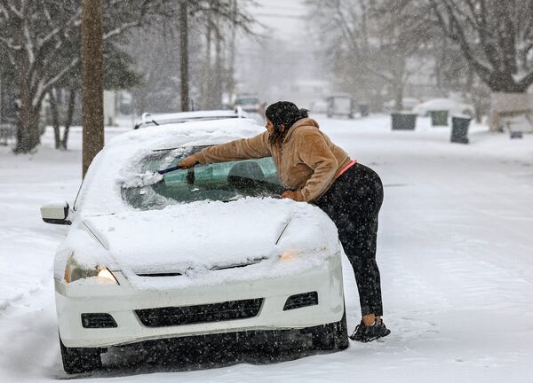 Kaila Powell works to clear the windshield of her car as snow falls, Friday, Jan. 10, 2025, in Owensboro, Ky. (Greg Eans/The Messenger-Inquirer via AP)