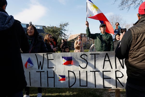 A supporter of former Philippine President Rodrigo Duterte waves a flag as he demonstrates outside the International Criminal Court detention center near The Hague in Scheveningen, Netherlands, Wednesday, March 12, 2025. (AP Photo/Omar Havana)