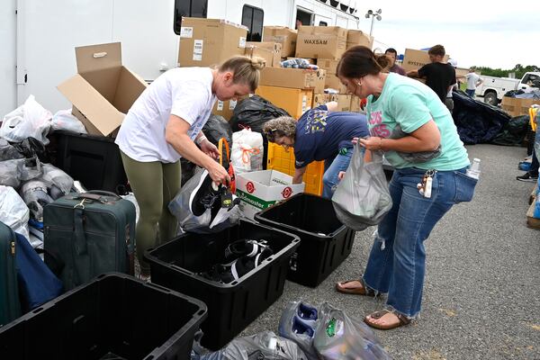 Volunteers sort clothing into bins for distribution at the command center set up at the London-Corbin Airport in London, Ky., Monday, May 19, 2025. (AP Photo/Timothy D. Easley)