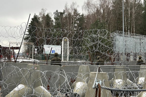 Polish border guards look east into Belarus at the crossing point Połowce-Pieszczatka in Polowce, Poland, Thursday, Jan. 16, 2025. (AP Photo/Lorne Cooke)