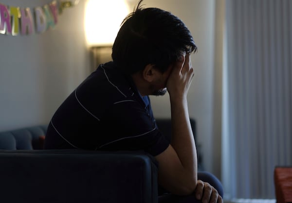 Rahmani, who has been experiencing anxiety and depression since the Trump administration cut federal funding for refugee programs, rubs his eyes while sitting in his apartment in Laurel, Md., Monday, March 3, 2025. (AP Photo/Jessie Wardarski)