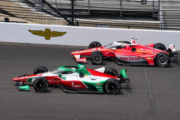 Callum Ilott, of the United Kingdom, (90) and Will Power, of Australia, drive into the first turn during practice for the Indianapolis 500 auto race at the Indianapolis Motor Speedway in Indianapolis, Monday, May 19, 2025. (AP Photo/Michael Conroy)