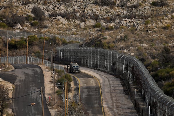 Israeli soldiers stand next to an armoured vehicle before crossing the security fence, moving towards the so-called Alpha Line that separates the Israeli-controlled Golan Heights from Syria, in the town of Majdal Shams, Friday, Dec. 20, 2024. (AP Photo/Matias Delacroix)