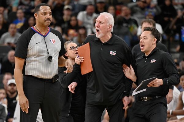 FILE - San Antonio Spurs head coach Gregg Popovich, second from right, yells at referee Bennie Adams, left, while being restrained by Spurs assistant coaches Mitch Johnson, right, and Becky Hammon during the first half of an NBA basketball game against the New Orleans Pelicans on Friday, March 18, 2022, in San Antonio. (AP Photo/Darren Abate, File)