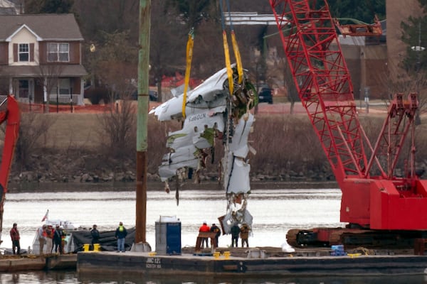 Crews pull up a part of a plane from the Potomac River near Ronald Reagan Washington National Airport, Monday, Feb. 3, 2025, in Arlington, Va. (AP Photo/Jose Luis Magana)