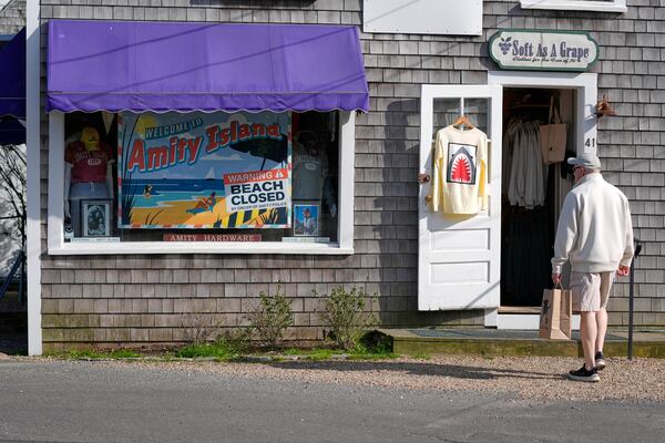 A visitor arrives at a shop selling Jaws-related souvenirs, Wednesday, May 14, 2025, in Edgartown, Mass. (AP Photo/Robert F. Bukaty)