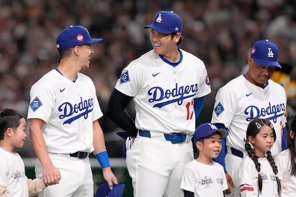 Los Angeles Dodgers' Tommy Edman, from top left, Shohei Ohtani (17) and manager Dave Roberts stand on the field before an MLB Japan Series exhibition baseball game against the Hanshin Tigers, Sunday, March 16, 2025, in Tokyo. (AP Photo/Eugene Hoshiko)