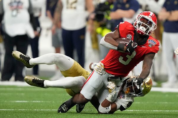 Georgia running back Nate Frazier (3) is tackled by Notre Dame safety Xavier Watts during the second half in the quarterfinals of a College Football Playoff, Thursday, Jan. 2, 2025, in New Orleans. (AP Photo/Gerald Herbert)