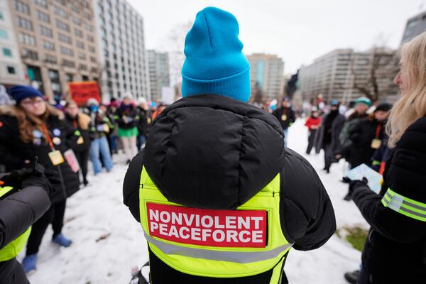 A volunteer speaks to others in Farragut Square before the start of the People's March, Saturday, Jan. 18, 2025, in Washington. (AP Photo/Mike Stewart)