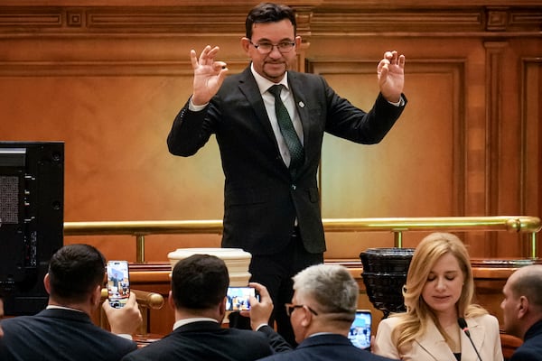 A member of parliament casts his vote during a confidence vote for Romanian Prime Minister designate Marcel Ciolacu, the leader of the Social Democratic party, and his team at the parliament in Bucharest, Romania, Monday, Dec. 23, 2024. (AP Photo/Vadim Ghirda)