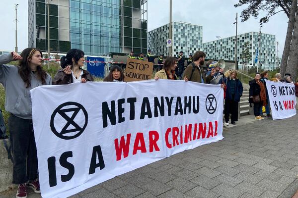 FILE - Activists hold up a banner denouncing Israeli Prime Minister Benjamin Netanyahu for Israel's actions during the war with Hamas as they demonstrate at the entrance of the International Criminal Court in The Hague, Netherlands, Oct. 23, 2023. (AP Photo/Aleks Furtula, File)