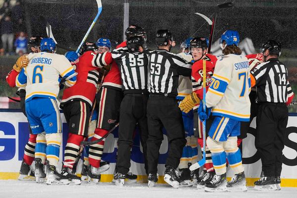 Officials break up a fight between the St. Louis Blues and Chicago Blackhawks during the second period of the NHL Winter Classic outdoor hockey game at Wrigley Field, Tuesday, Dec. 31, 2024, in Chicago. (AP Photo/Erin Hooley)