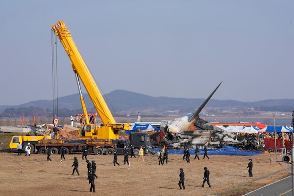 Firefighters and rescue team members work near the wreckage of a passenger plane at Muan International Airport in Muan, South Korea, Sunday, Dec. 29, 2024. (AP Photo/Ahn Young-joon)