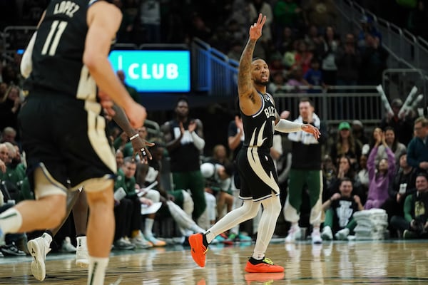 Milwaukee Bucks' Damian Lillard, center, gestures during the second half of an NBA basketball game against the Philadelphia 76ers, Sunday, Jan. 19, 2025, in Milwaukee. (AP Photo/Aaron Gash)