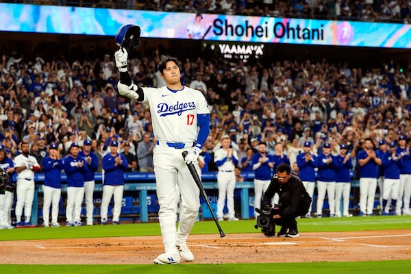 FILE - Los Angeles Dodgers designated hitter Shohei Ohtani (17) is honored for being first MLB player to achieve 50 home runs and 50 stolen bases in a single season during the first inning of a baseball game against the Colorado Rockies in Los Angeles, Friday, Sept. 20, 2024. (AP Photo/Ashley Landis, File)