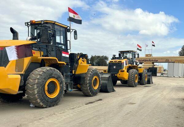 Bulldozers with Egyptian and Qatar flags wait to enter Gaza at the Rafah border crossing between Egypt and the Gaza Strip, Thursday, Feb. 13, 2025. (AP Photo/Mohamed Arafat)