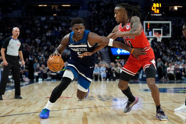 Minnesota Timberwolves guard Anthony Edwards (5) works toward the basket as Chicago Bulls guard Ayo Dosunmu (11) defends during the first half of an NBA basketball game, Wednesday, Feb. 5, 2025, in Minneapolis. (AP Photo/Abbie Parr)