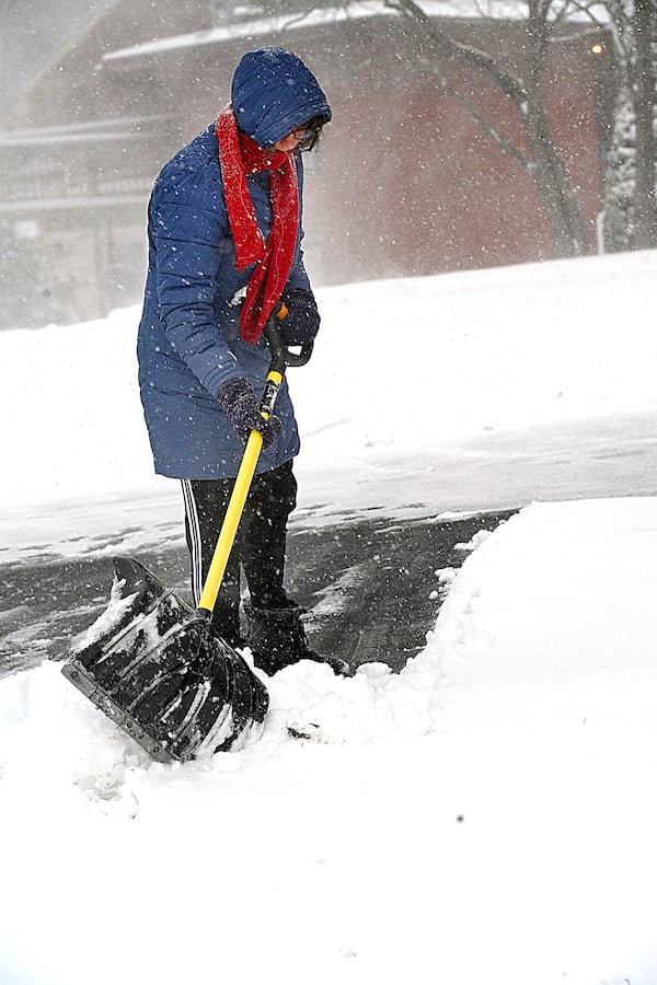 Elizabeth Cormack cleans snow off her driveway on West Logust Street in Beckley, W.V., Tuesday, Feb. 12, 2025. (Rick Barbero/The Register-Herald via AP)