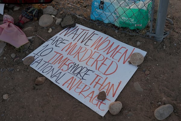 A sign lies on the ground at a vigil for slain Native American teen Emily Pike in Mesa, Ariz., Thursday, March 6, 2025. (AP Photo/Samantha Chow)