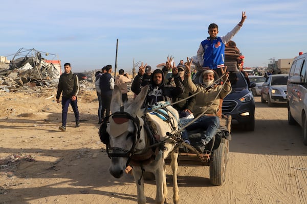 Displaced Palestinians flash V-sign as they return to Rafah, while a ceasefire deal between Israel and Hamas went into effect, in Rafah, Gaza Strip, Sunday, Jan. 19, 2025. (AP Photo/Mariam Dagga)