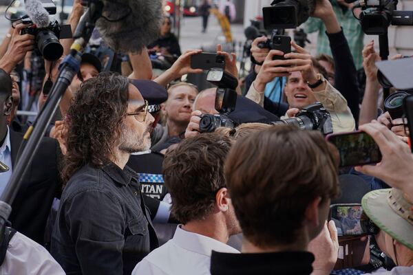 Russell Brand surrounded by media as he arrives at Westminster Magistrates' court in London, Friday, May 2, 2025, where he faces, rape and sexual assault charges involving four women. (AP Photo/Alberto Pezzali)