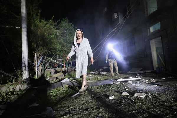 A man walks in a yard of a residential building destroyed by a Russian strike in Zaporizhzhia, Ukraine, Thursday, May 1, 2025. (AP Photo/Kateryna Klochko)