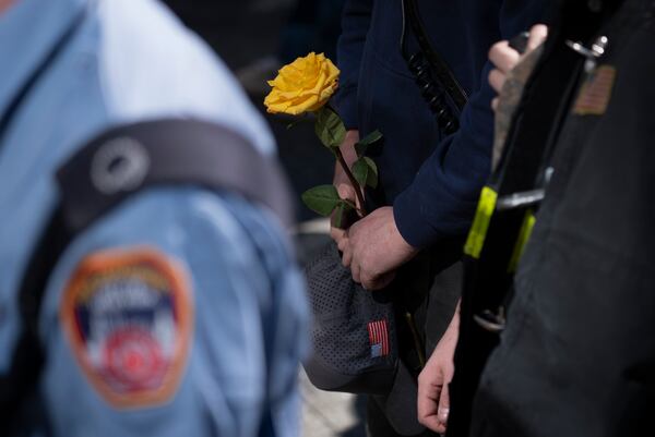 A firefighter holds a flower during a ceremony marking the anniversary of the 1993 World Trade Center bombing at the 9/11 Memorial, Wednesday, Feb. 26, 2025, in New York. (AP Photo/John Minchillo)