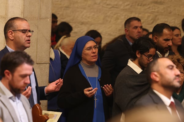 Christians attend the Christmas midnight Mass at the Church of the Nativity traditionally believed to be the birthplace of Jesus, in the West Bank city of Bethlehem, Tuesday Dec. 24, 2024. (Alaa Badarneh/Pool via EPA)