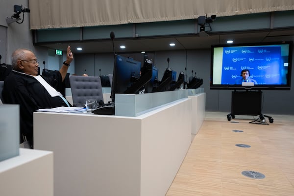 Former Philippine President Rodrigo Duterte is seen on a screen in the courtroom of the International Criminal Court (ICC) with his lawyer Salvador Medialdea seated left, in The Hague, Netherlands, Friday, March 14, 2025. (AP Photo/Peter Dejong, Pool)