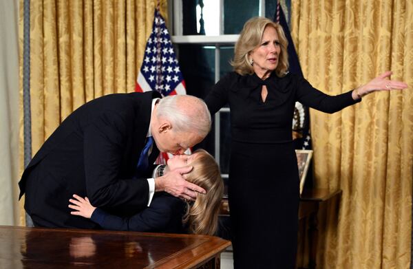 President Joe Biden kisses his grandson Beau Biden as first lady Jill Biden gestures after giving his farewell address from the Oval Office of the White House Wednesday, Jan. 15, 2025, in Washington. (Mandel Ngan/Pool via AP)