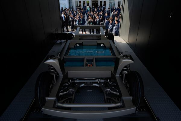 Attendees look at the next generation battery swapping station from China-based CATL, the world's largest maker of batteries for electric vehicles, before a launch presentation held in Xiamen, southern China's Fujian province on Wednesday, Dec. 18, 2024. (AP Photo/Ng Han Guan)