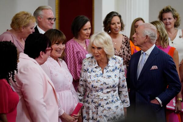 Britain's King Charles III and Queen Camilla speak with presenter Lorraine Kelly, second left, and the members of the Change + Check Choir, during a reception in Buckingham Palace, London, in celebration of community-based initiatives raising awareness about cancer and supporting those living with cancer, Wednesday April 30, 2025. (Andrew Matthews/Pool Photo via AP)