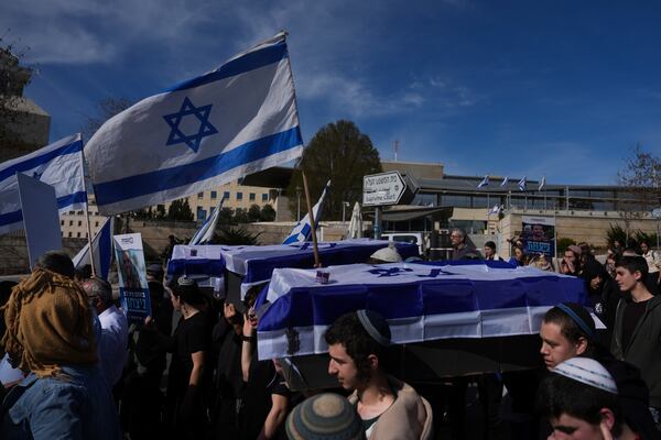 Activists representing families of Israelis killed during the war in Gaza carry mock coffins covered with Israeli flags that are meant to symbolize the price Israel will pay for agreeing to a ceasefire with Hamas in a demonstration against the deal , in Jerusalem on Thursday, Jan. 16, 2025. (AP Photo/Ohad Zwigenberg)