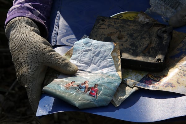 A photo sits on top of other lost items Jill Holtz collected in the woods near a cornfield in Swannanoa, N.C., on Thursday, Feb. 6, 2025. (AP Photo/Makiya Seminera)