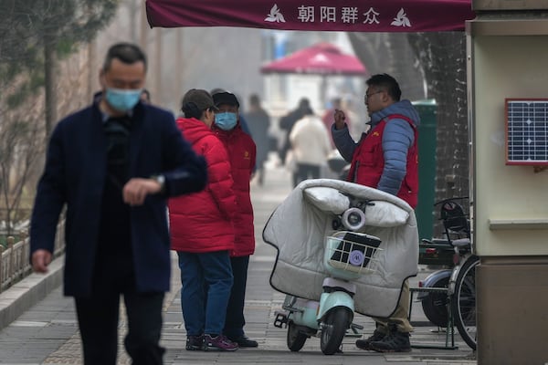 Volunteers from the "Chaoyang Qunzhong," a vigilant citizens group, keep watch on the streets ahead of the National People's Congress in Beijing on Saturday, March 1, 2025. (AP Photo/Andy Wong)