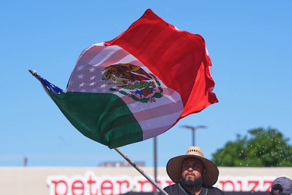 A float rider waves a U.S.-Mexico flag during a Cinco de Mayo parade in the Oak Cliff section of Dallas, Saturday, May 3, 2025. (AP Photo/LM Otero)