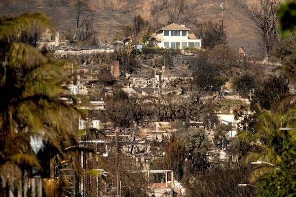 A home stands among residences destroyed by the Palisades Fire in the Pacific Palisades neighborhood of Los Angeles on Sunday, Jan. 12, 2025. (AP Photo/Noah Berger)