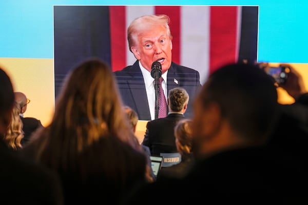 People watch the inauguration of Donald Trump on screens at the Ukraine house alongside the World Economic Forum in Davos, Switzerland, Monday, Jan. 20, 2025. (AP Photo/Markus Schreiber)