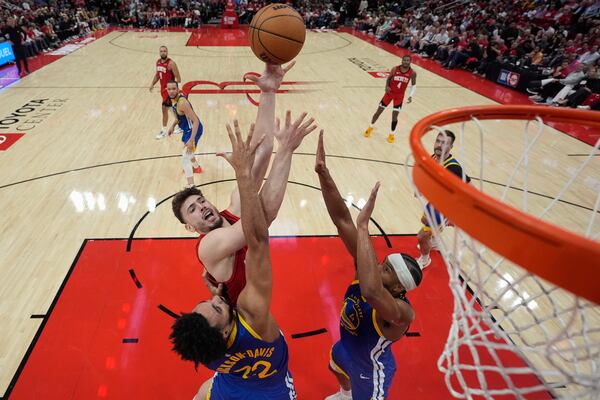 Houston Rockets center Alperen Sengun shoots over Golden State Warriors forward Trayce Jackson-Davis (32) and guard Moses Moody (4) during the second half of Game 5 of an NBA basketball first-round playoff series, Wednesday, April 30, 2025, in Houston. (AP Photo/David J. Phillip)