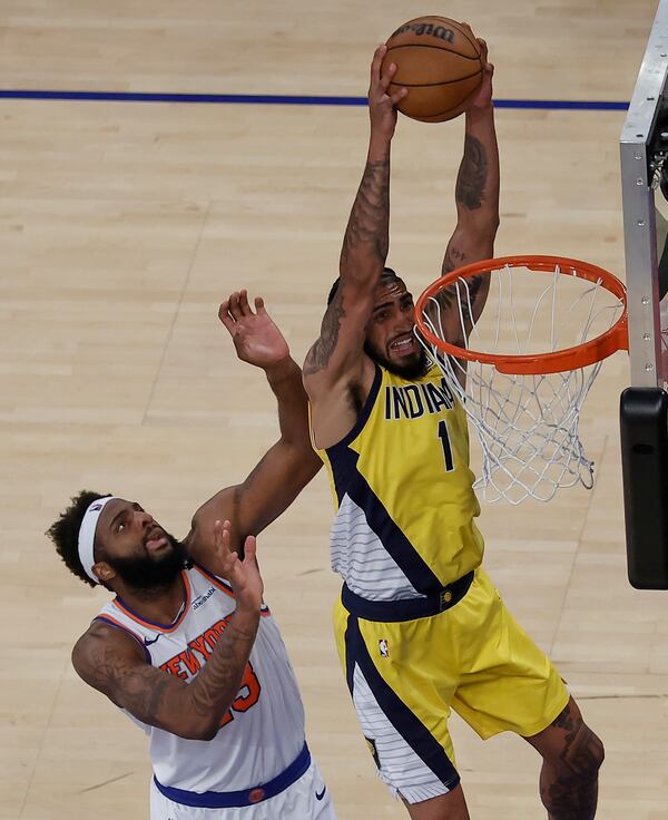 Indiana Pacers forward Obi Toppin (1) dunks the ball against New York Knicks center Mitchell Robinson (23) in overtime of Game 1 of the NBA basketball Eastern Conference final, Wednesday, May 21, 2025, in New York. (AP Photo/Adam Hunger)
