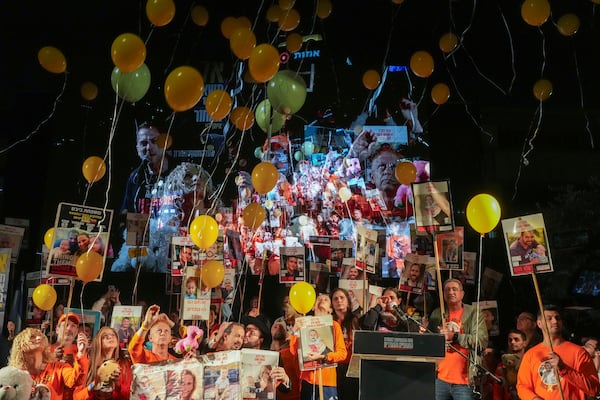 Balloons are released as demonstrators hold portraits of hostages held by Hamas in the Gaza Strip during a protest calling for their immediate release in Tel Aviv, Israel, Saturday Jan. 18, 2025. (AP Photo/Ohad Zwigenberg)