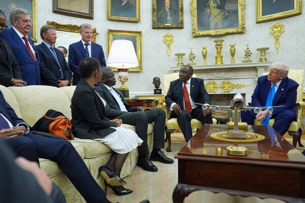 President Donald Trump meets South African President Cyril Ramaphosa in the Oval Office of the White House, Wednesday, May 21, 2025, in Washington, as South African businessman Johann Rupert, looks on, upper left. (AP Photo/Evan Vucci)