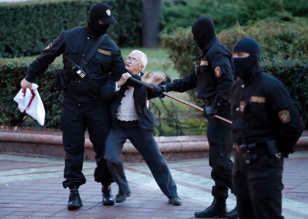 FILE - Opposition activist Nina Bahinskaya, 73, center, struggles with police during a Belarusian opposition supporters rally at Independence Square in Minsk, Belarus, Wednesday, Aug. 26, 2020. (AP Photo/Dmitri Lovetsky, File)