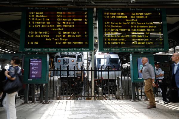 FILe - People head to trains at the New Jersey Transit station in Hoboken, N.J., on Tuesday, Aug. 7, 2018. (AP Photo/David Boe, File)