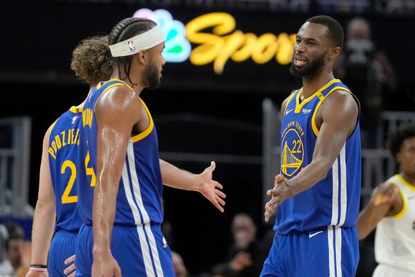 Golden State Warriors forward Andrew Wiggins, right, celebrates with guard Brandin Podziemski, left, and guard Moses Moody during the second half of an NBA basketball game against the Utah Jazz in San Francisco, Tuesday, Jan. 28, 2025. (AP Photo/Jeff Chiu)